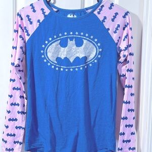 It is a blue and pink shirt with Batman has a silver Batman in the middle.